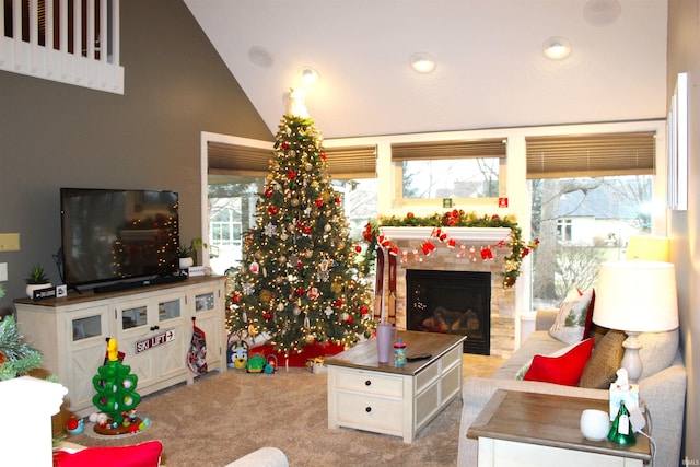 living room with a tile fireplace, lofted ceiling, light colored carpet, and a healthy amount of sunlight