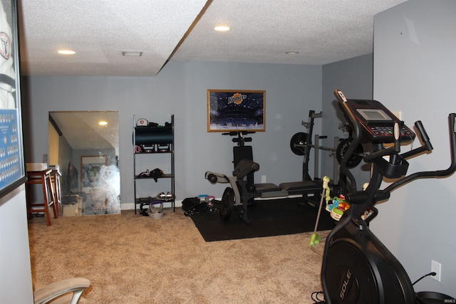 exercise room featuring carpet flooring and a textured ceiling