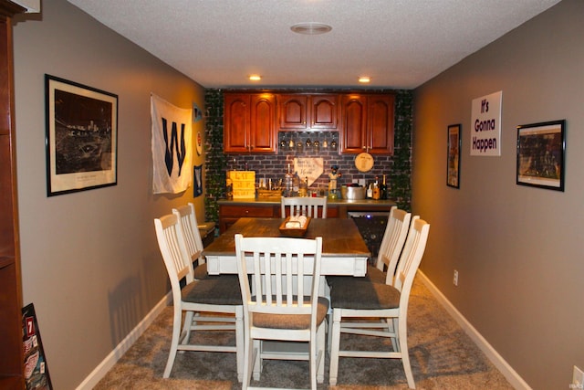 dining area featuring dark colored carpet and a textured ceiling