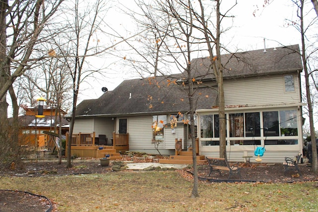 back of property with a sunroom, a yard, and a deck