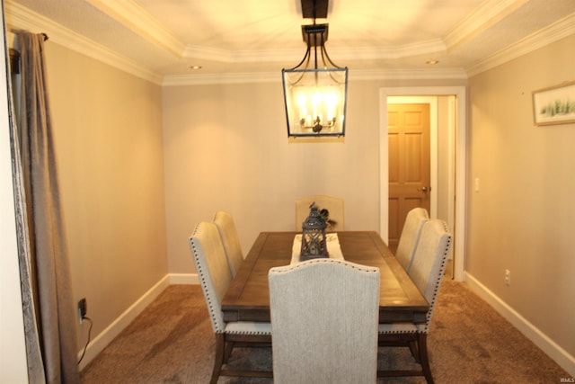 carpeted dining area featuring a tray ceiling, an inviting chandelier, and ornamental molding