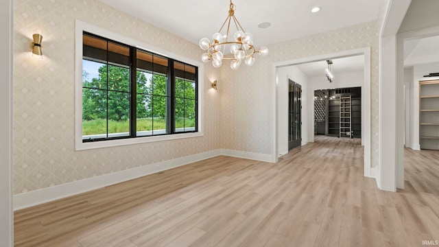 unfurnished dining area with a chandelier and light wood-type flooring