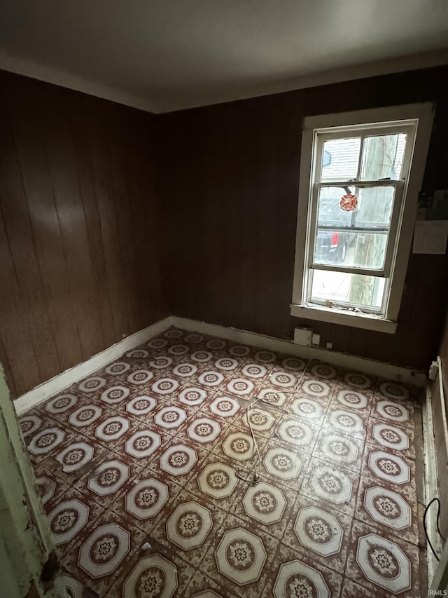 unfurnished room featuring wooden walls