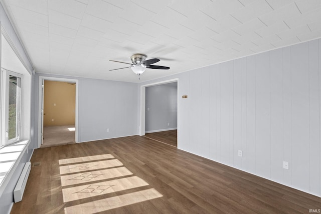 empty room featuring ceiling fan, dark wood-type flooring, and a baseboard radiator