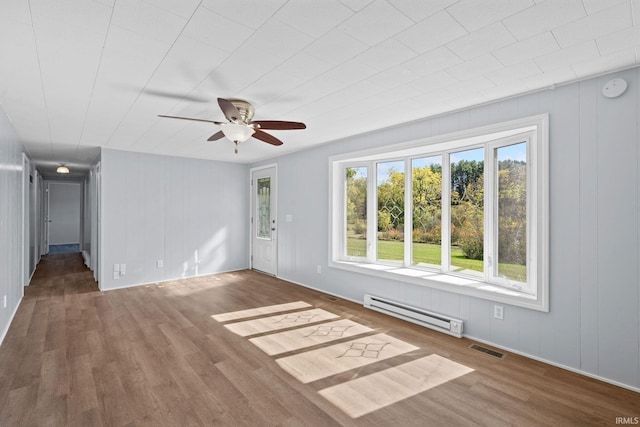 spare room with hardwood / wood-style flooring, ceiling fan, and a baseboard radiator