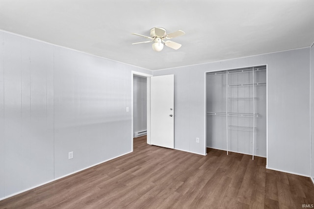 unfurnished bedroom featuring dark hardwood / wood-style floors, baseboard heating, and ceiling fan