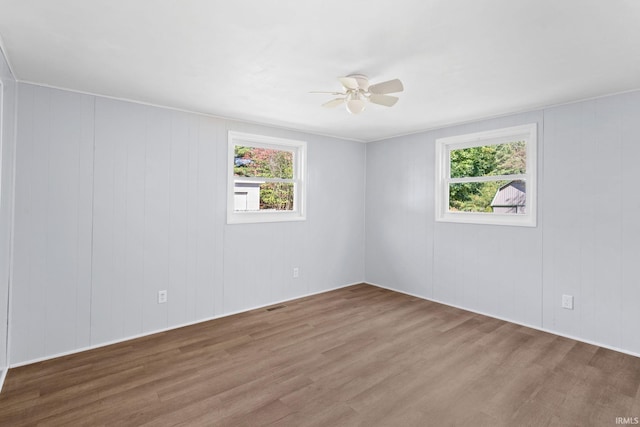 empty room with hardwood / wood-style flooring and ceiling fan