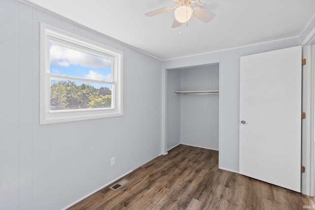 unfurnished bedroom featuring dark hardwood / wood-style flooring, a closet, and ceiling fan