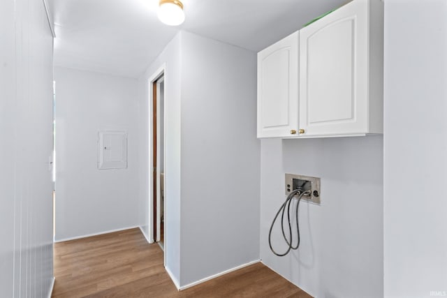 laundry room with electric panel, light hardwood / wood-style flooring, cabinets, and washer hookup