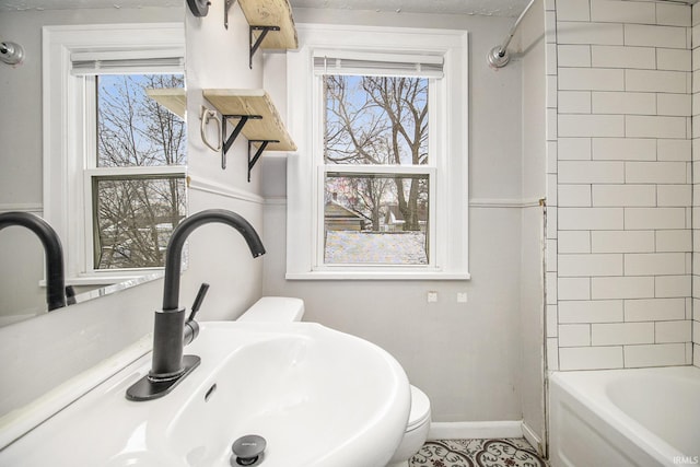 bathroom featuring tiled shower / bath, plenty of natural light, and sink