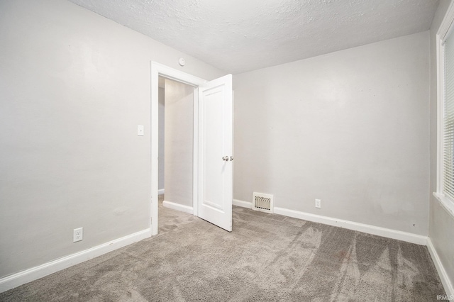 unfurnished room featuring carpet flooring and a textured ceiling