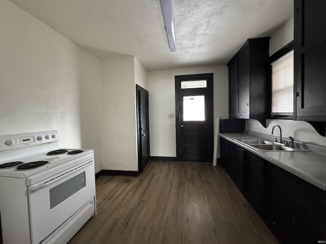 kitchen featuring dark hardwood / wood-style flooring, electric stove, sink, and a textured ceiling