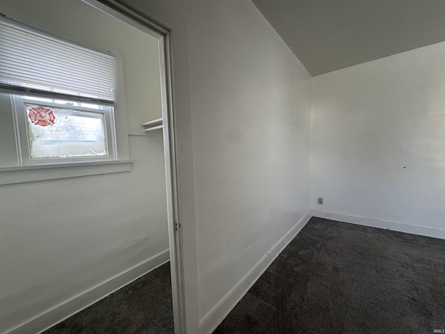 interior space with dark colored carpet and vaulted ceiling