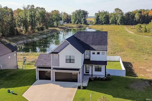 view of front facade with a water view, a front yard, and a garage