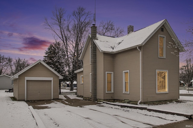 view of snow covered exterior featuring an outdoor structure and a garage