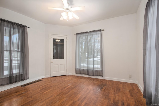 empty room featuring hardwood / wood-style floors, a wealth of natural light, and ceiling fan