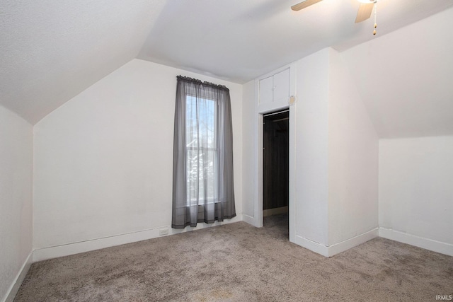 additional living space featuring ceiling fan, light colored carpet, and vaulted ceiling