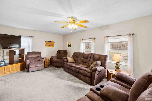 carpeted living room with ceiling fan