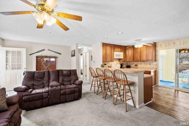 living room featuring light carpet and ceiling fan