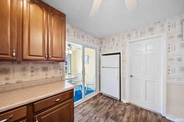 kitchen featuring dark hardwood / wood-style flooring, white fridge, a textured ceiling, and ceiling fan