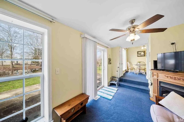 living room with ceiling fan and dark carpet