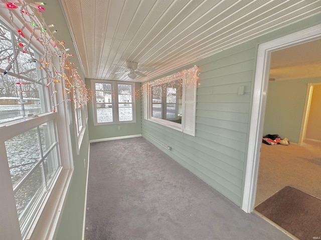 unfurnished sunroom with wooden ceiling, ceiling fan, and a healthy amount of sunlight