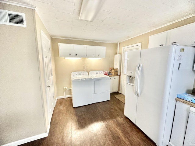 washroom with cabinets, dark hardwood / wood-style flooring, ornamental molding, and washing machine and clothes dryer