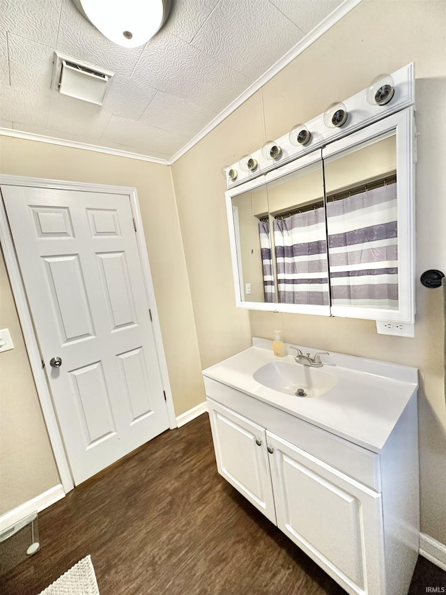 bathroom with hardwood / wood-style floors, vanity, and ornamental molding