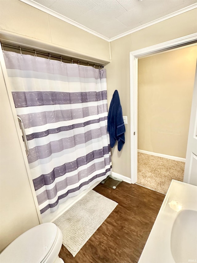 bathroom featuring toilet, vanity, wood-type flooring, and ornamental molding