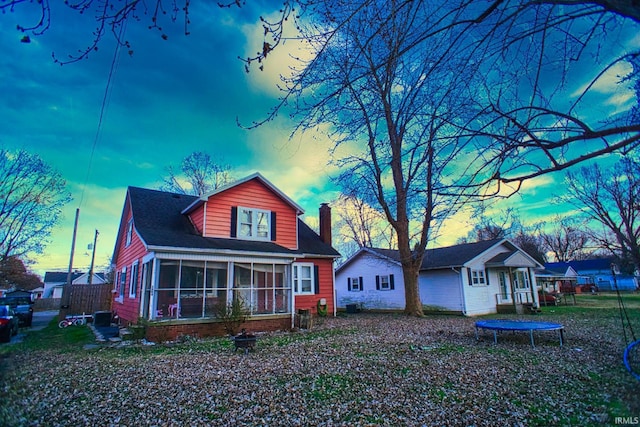 view of front facade featuring a trampoline and a sunroom