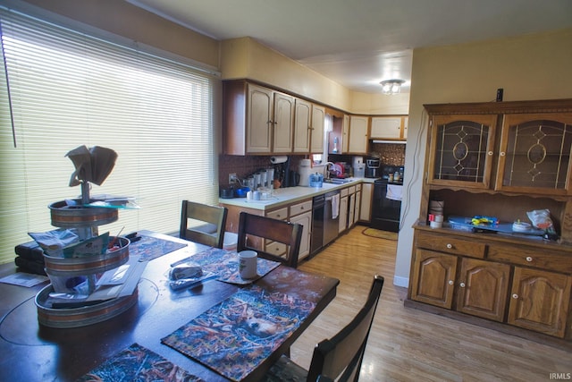 kitchen featuring black electric range oven, sink, light hardwood / wood-style flooring, dishwasher, and tasteful backsplash