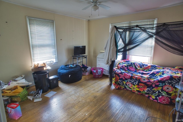 bedroom featuring hardwood / wood-style flooring, ornamental molding, and ceiling fan