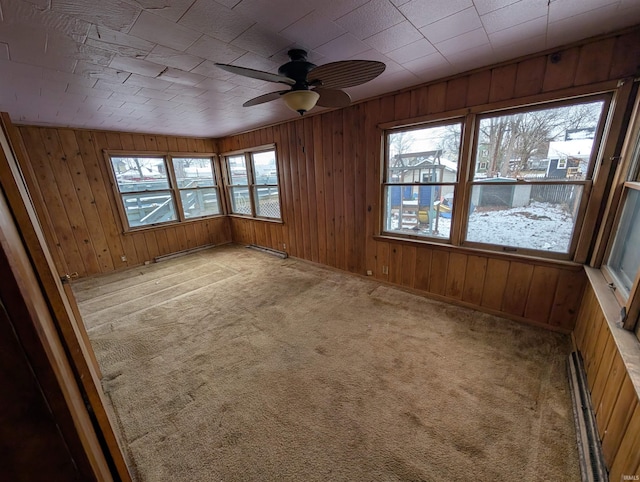 carpeted spare room with baseboard heating and ceiling fan