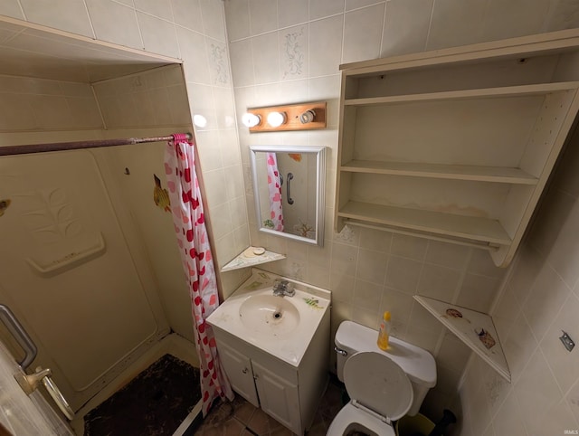 bathroom with vanity, tile walls, and toilet