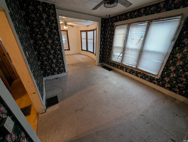 spare room featuring light carpet and ceiling fan