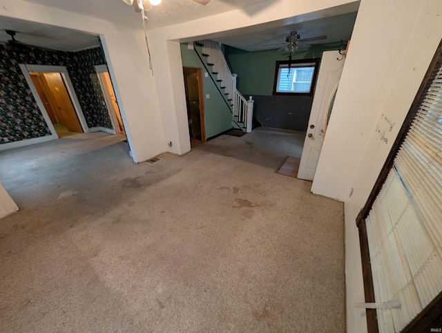 interior space with carpet floors and ceiling fan