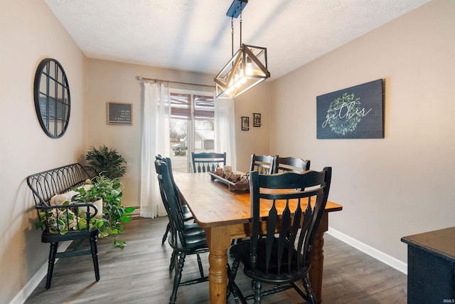 dining space featuring dark hardwood / wood-style floors and a textured ceiling