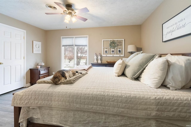 bedroom featuring ceiling fan, a textured ceiling, and hardwood / wood-style flooring