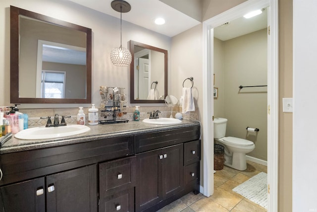 bathroom with tile patterned flooring, vanity, and toilet