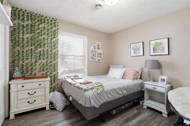 bedroom featuring dark wood-type flooring and a textured ceiling