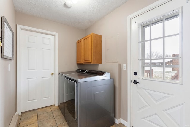 washroom featuring washer and dryer, light tile patterned flooring, cabinets, and plenty of natural light