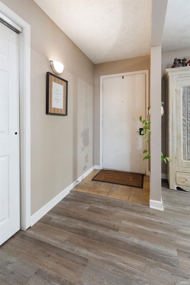 entrance foyer with a textured ceiling and hardwood / wood-style flooring