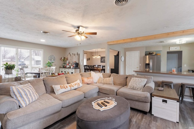 living room featuring dark hardwood / wood-style flooring, a textured ceiling, and ceiling fan