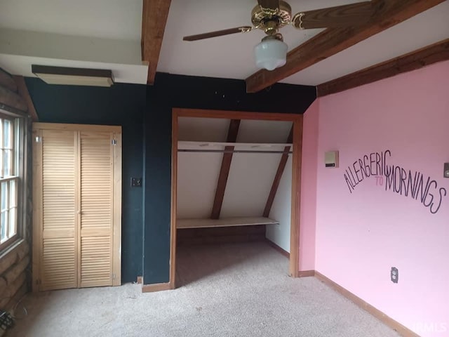 unfurnished bedroom with carpet flooring, ceiling fan, lofted ceiling with beams, and a closet