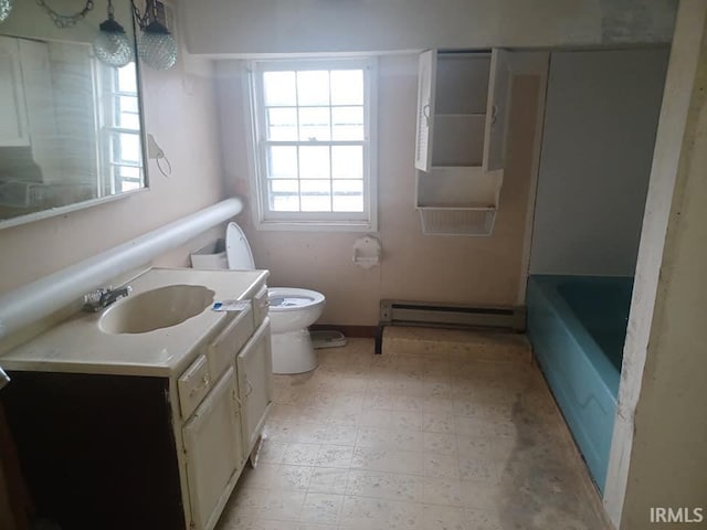 bathroom with vanity, a bathtub, toilet, and baseboard heating