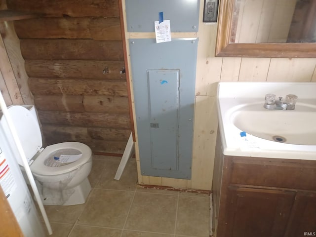 bathroom featuring tile patterned floors, vanity, toilet, and wooden walls