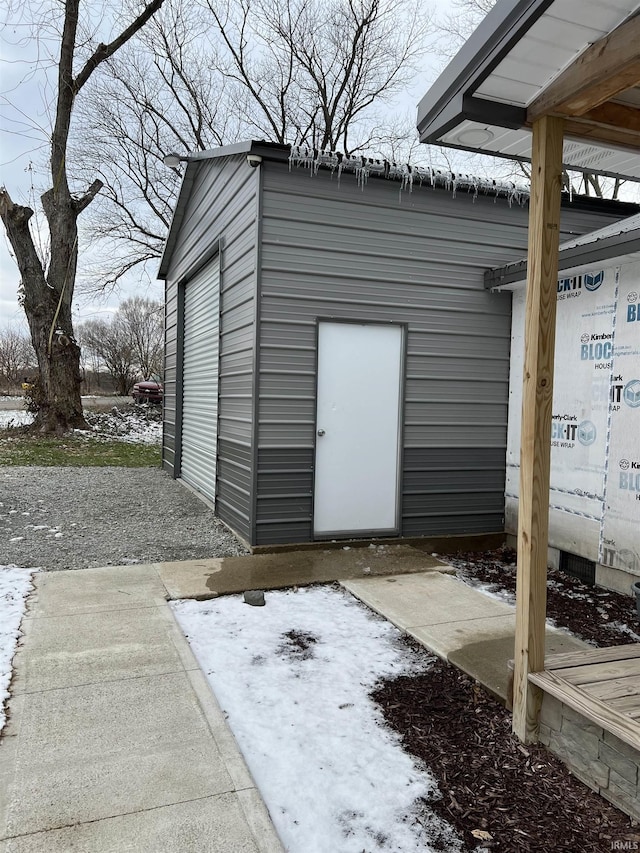 snow covered structure with a garage