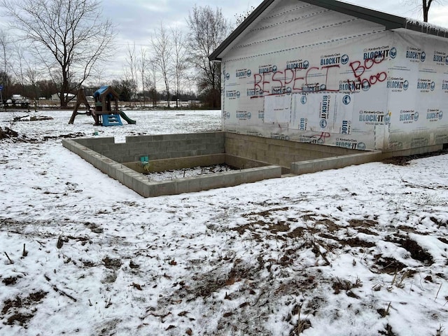 snow covered property with a playground