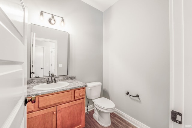 bathroom with hardwood / wood-style floors, vanity, and toilet