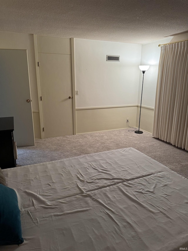 unfurnished bedroom with a textured ceiling and carpet floors